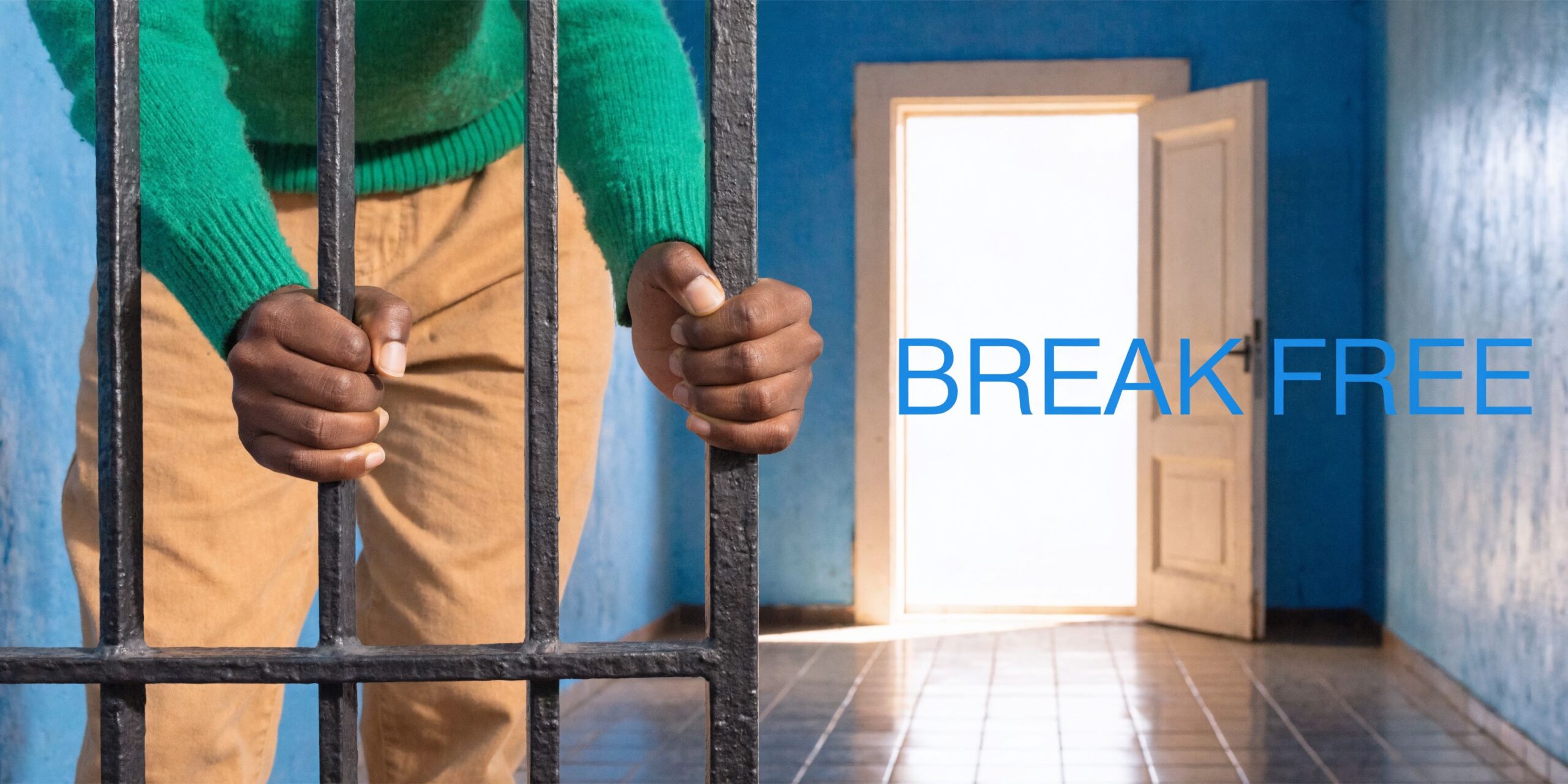 A person with hands gripping iron bars looking towards an open door, representing hope and liberation.